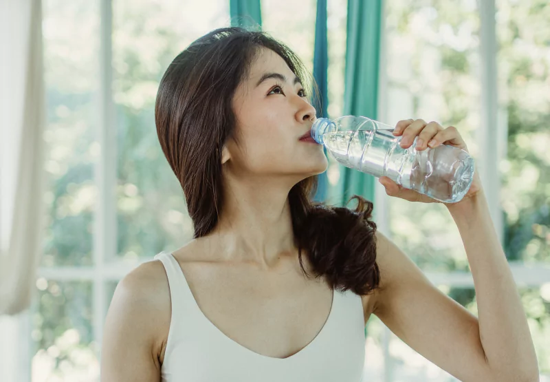 a woman drinking from a water bottle