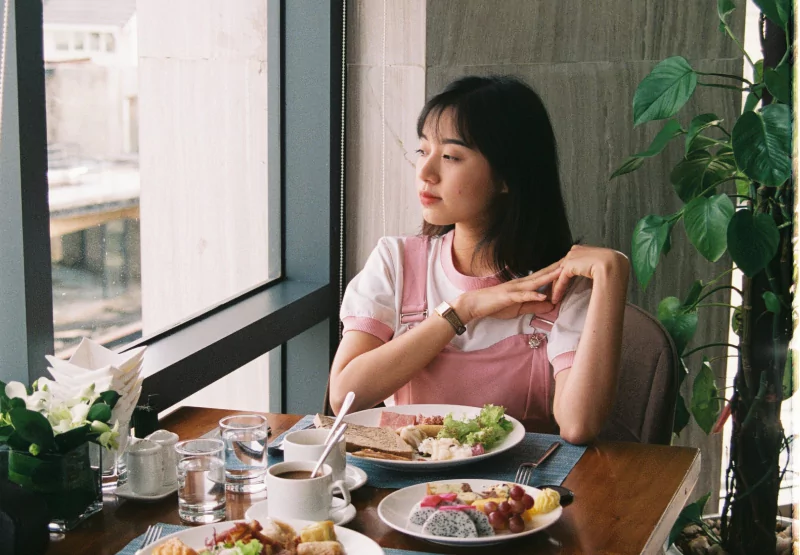 a girl looking out the window at a restaurant