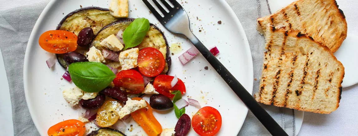 eggplants, tomatoes, onion on a plate and two toasts