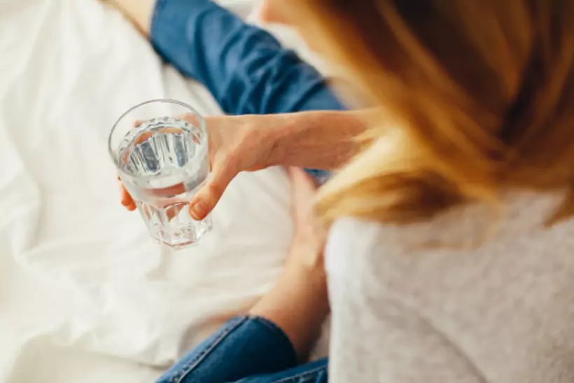a person holding a glass of water