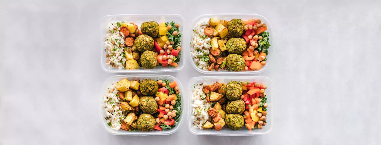 four lunch boxes of rice and vegetables