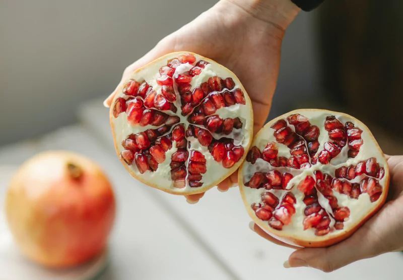 someone opening a whole pomegranate