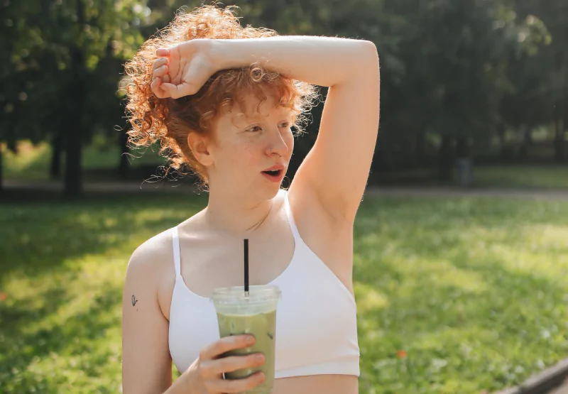 a girl drinking a matcha latte in the park