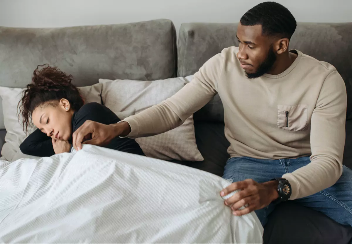 a man caring for a woman who is laying down