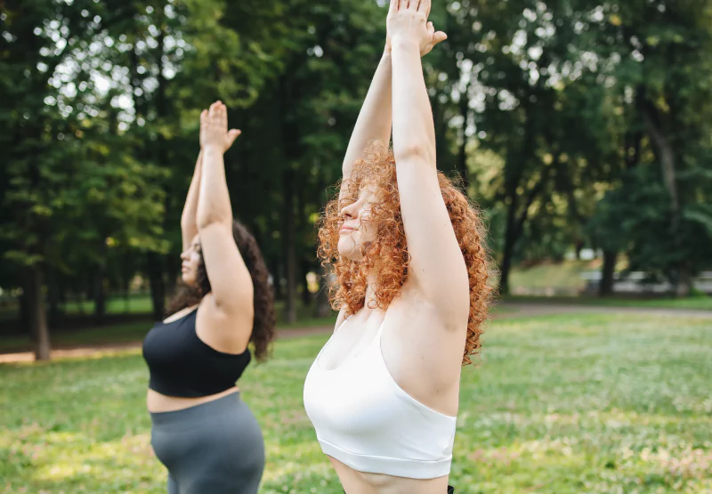 two girls doing yoga in the park