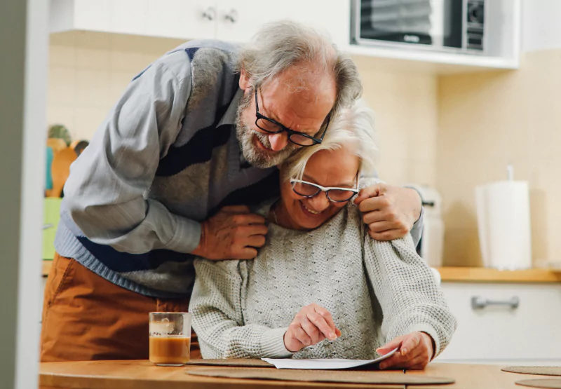 two older people hugging and smiling