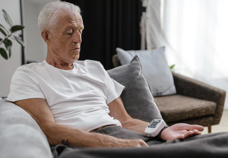 an old man sitting down and checking his blood pressure