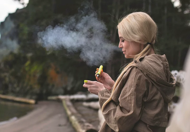 a girl smoking a vape outside