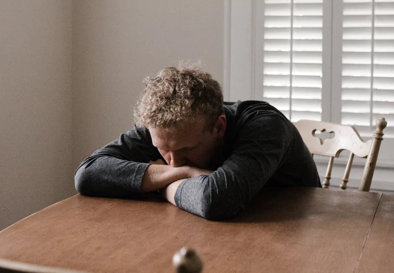 a man with his head down on a table