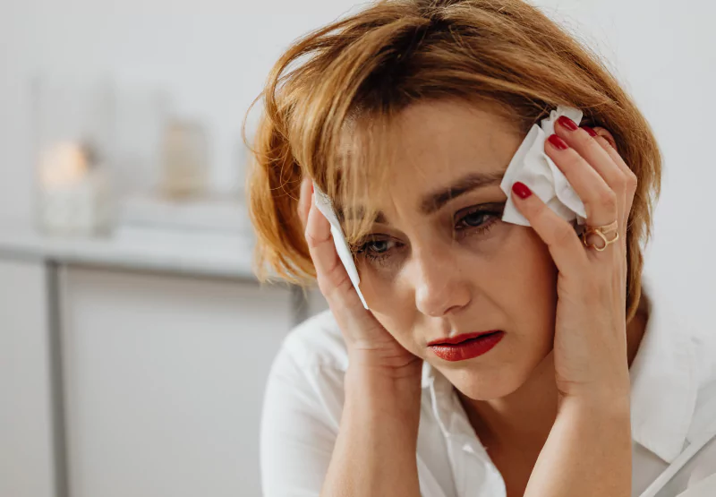 a woman icing her head and experiencing headache