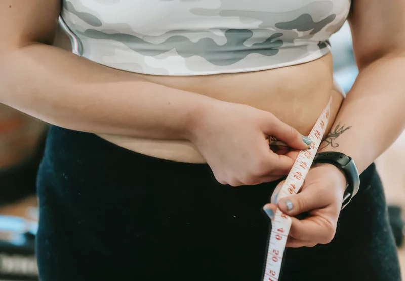 a woman measuring her waist