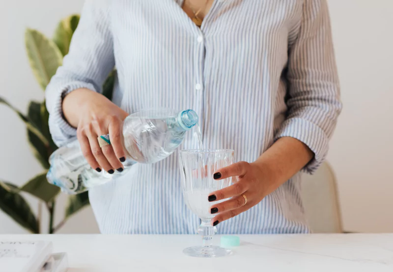 a woman pouring a glass of alkaline water