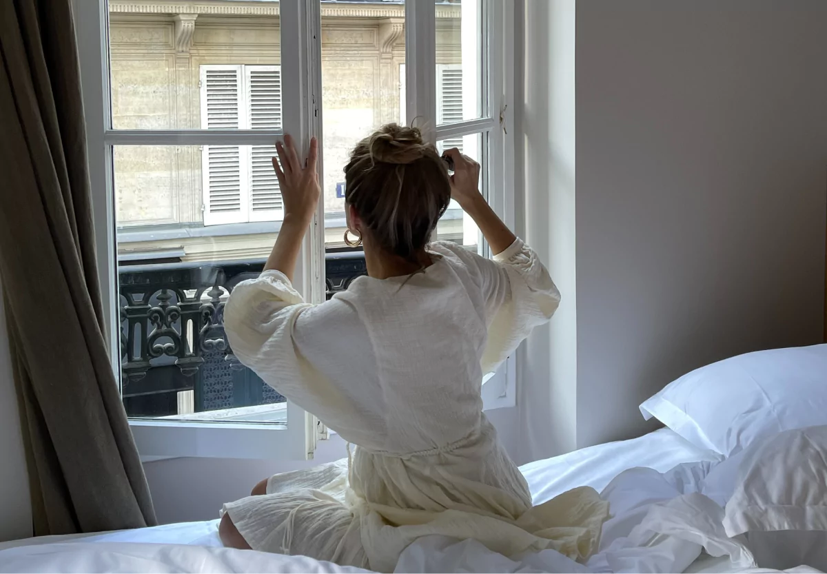 a woman closing her bedroom window