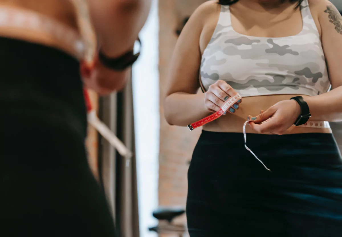 a woman measuring her waist