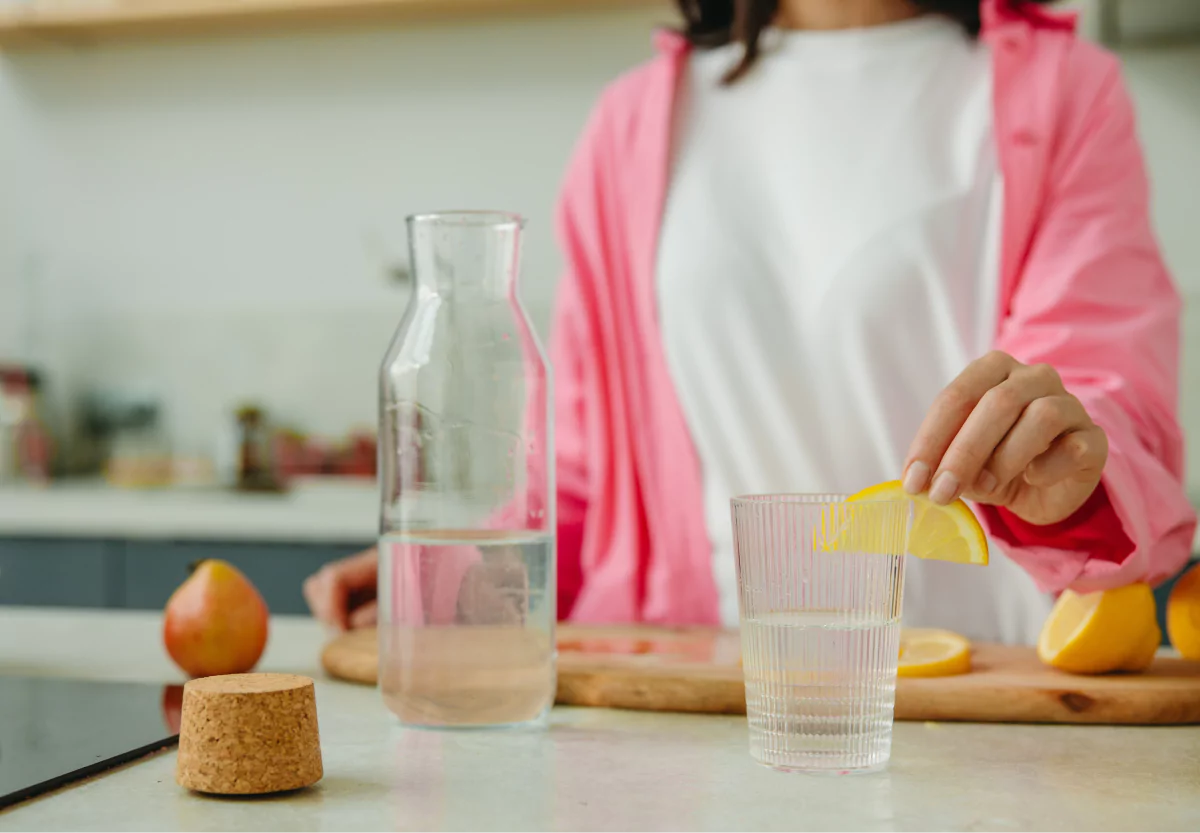 someone adding lemon to their water