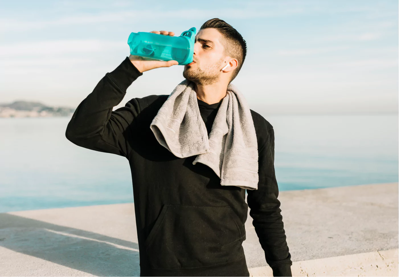 a man in workout clothes drinking water