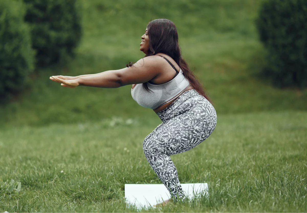 A woman exercising on the grass outdoors