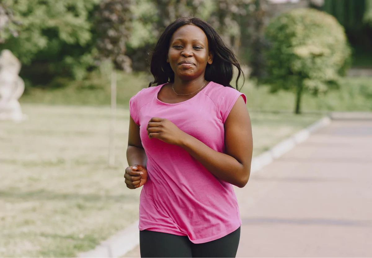 A woman in a pink top running outdoors