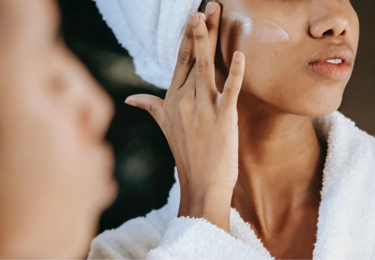 a woman applying sunscreen on her face