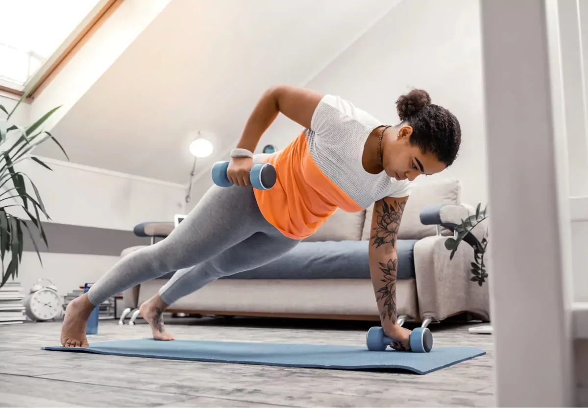 a woman doing renegade rows with dumbbells