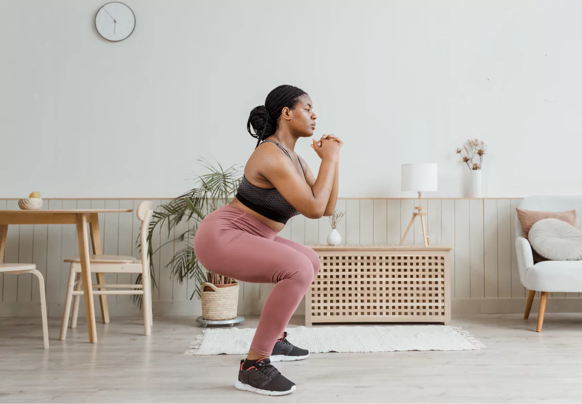 a woman doing a squat at home