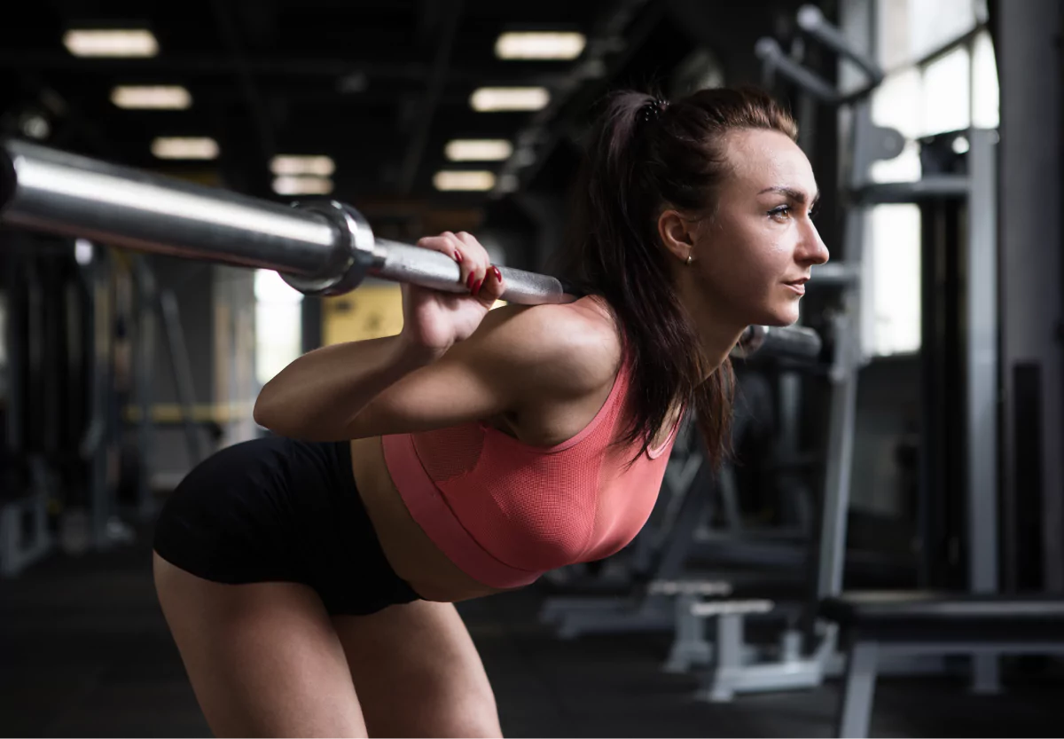 a girl doing good mornings with a barbell