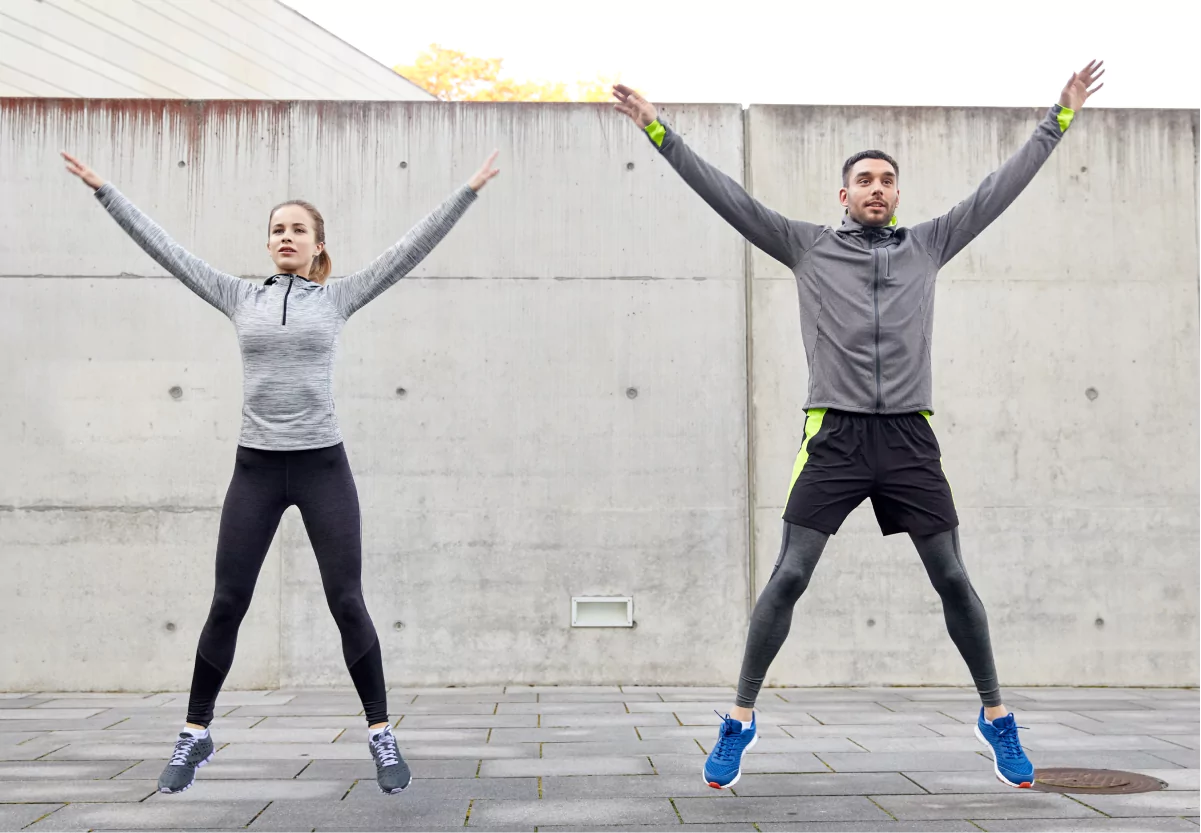 two people doing jumping jacks