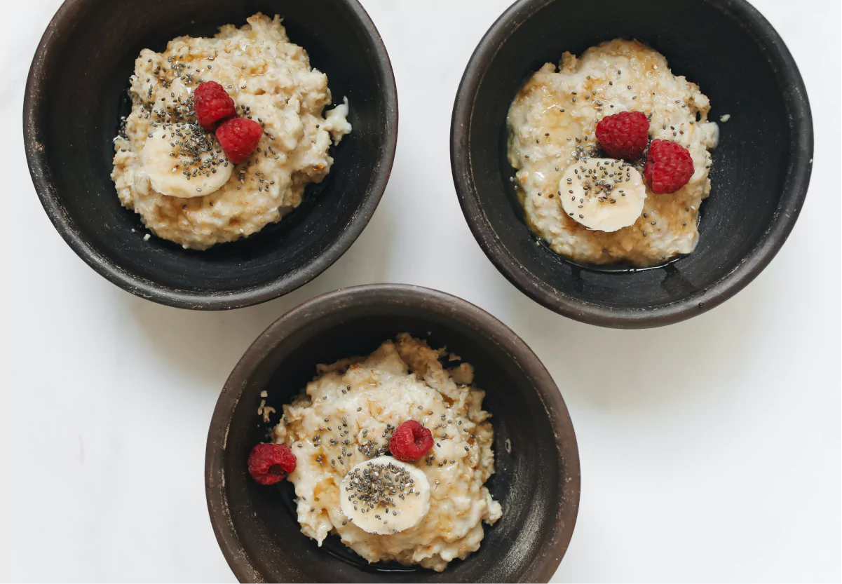 three bowls of flavored oatmeal with fruit and chia