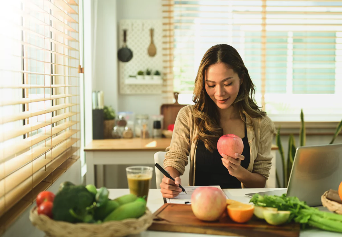 a dietitian holding an apple and taking notes