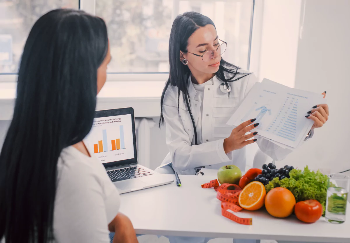 a dietitian holding a chart and talking to her client