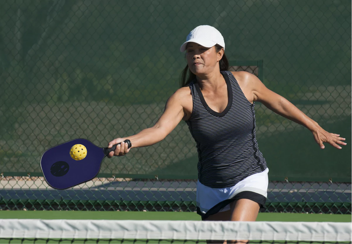 a woman swinging a pickleball racket