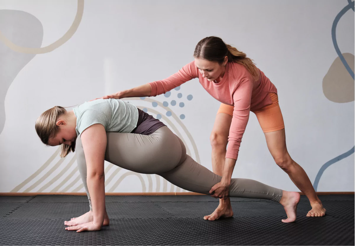 a girl doing yoga with a teacher