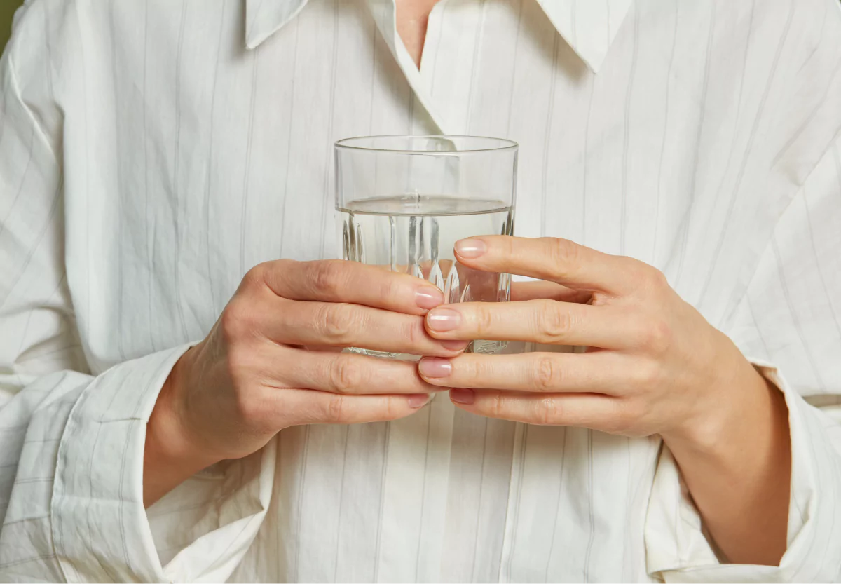 someone holding a glass of water