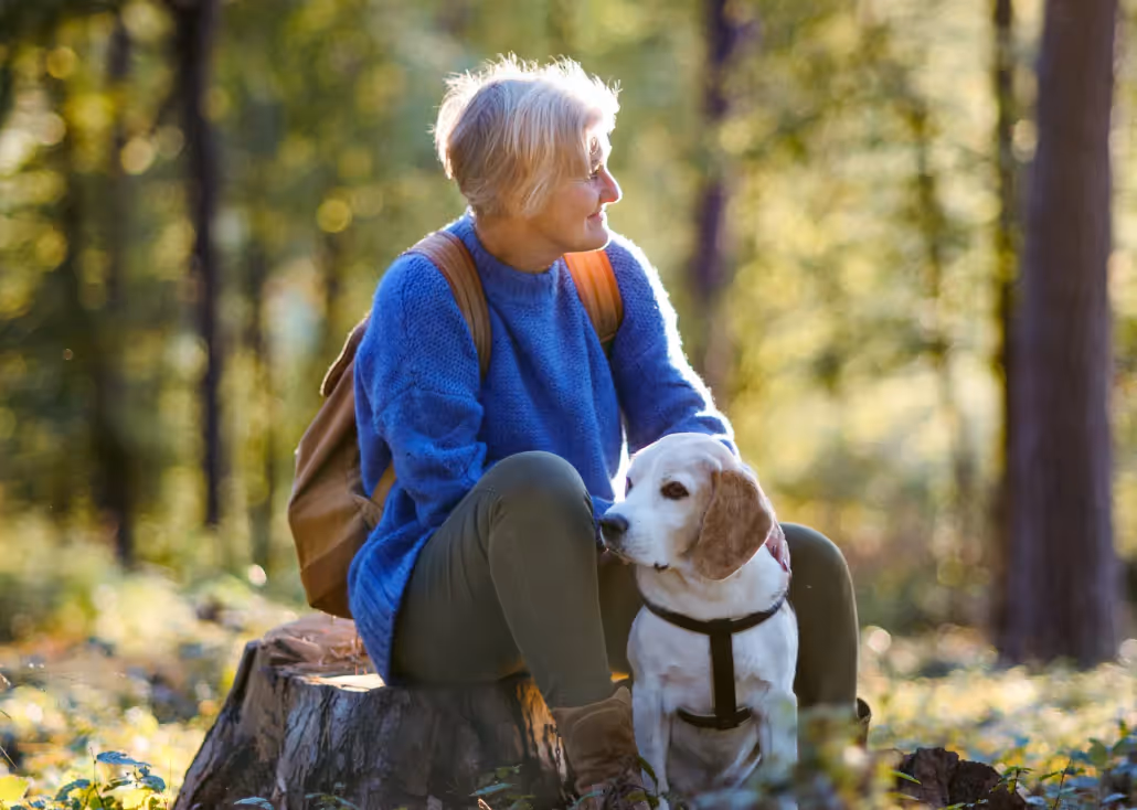 an older adult on a walk outside with their dog