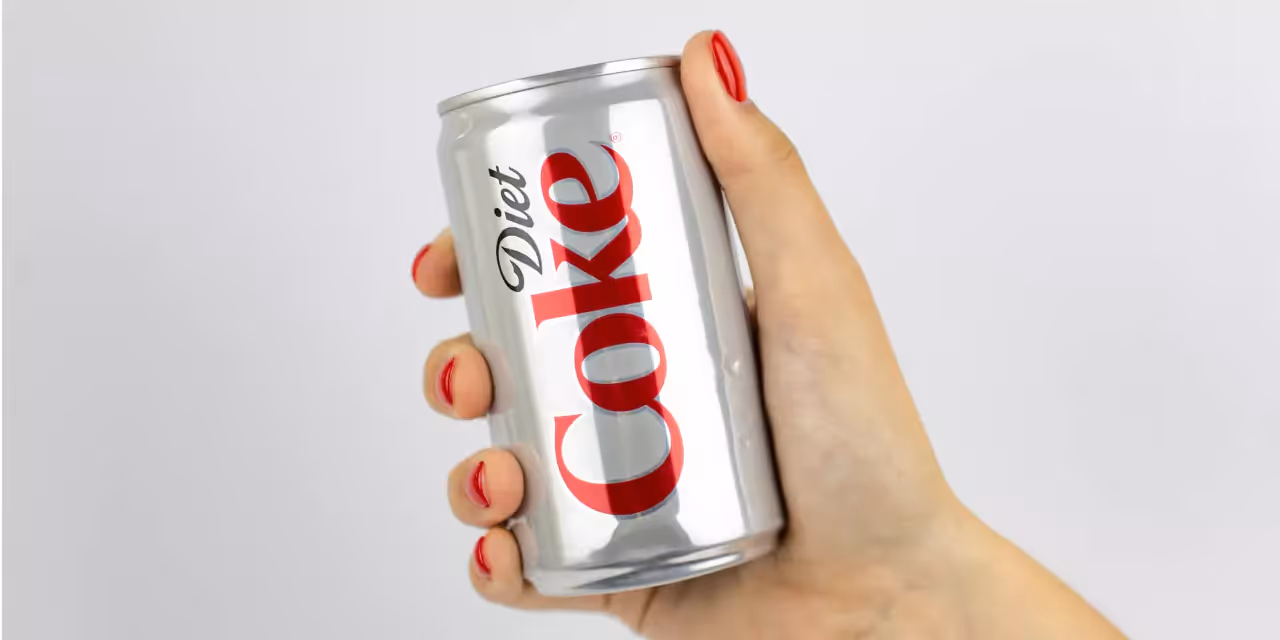 A closeup of a hand holding a can of Diet Coca Cola