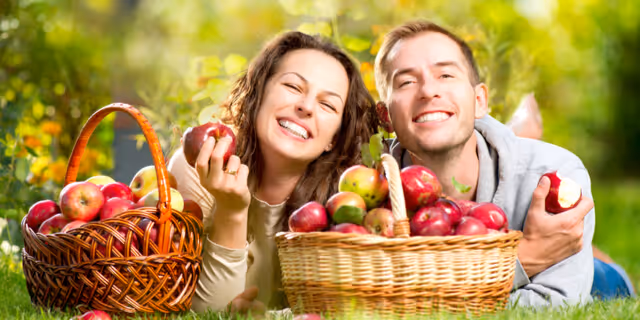 Man and woman eating apples