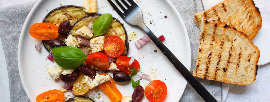eggplants, tomatoes, onion on a plate and two toasts