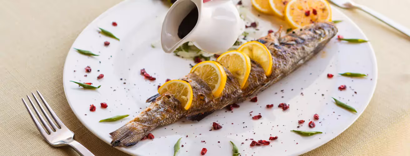 a baked fish with lemon on a plate