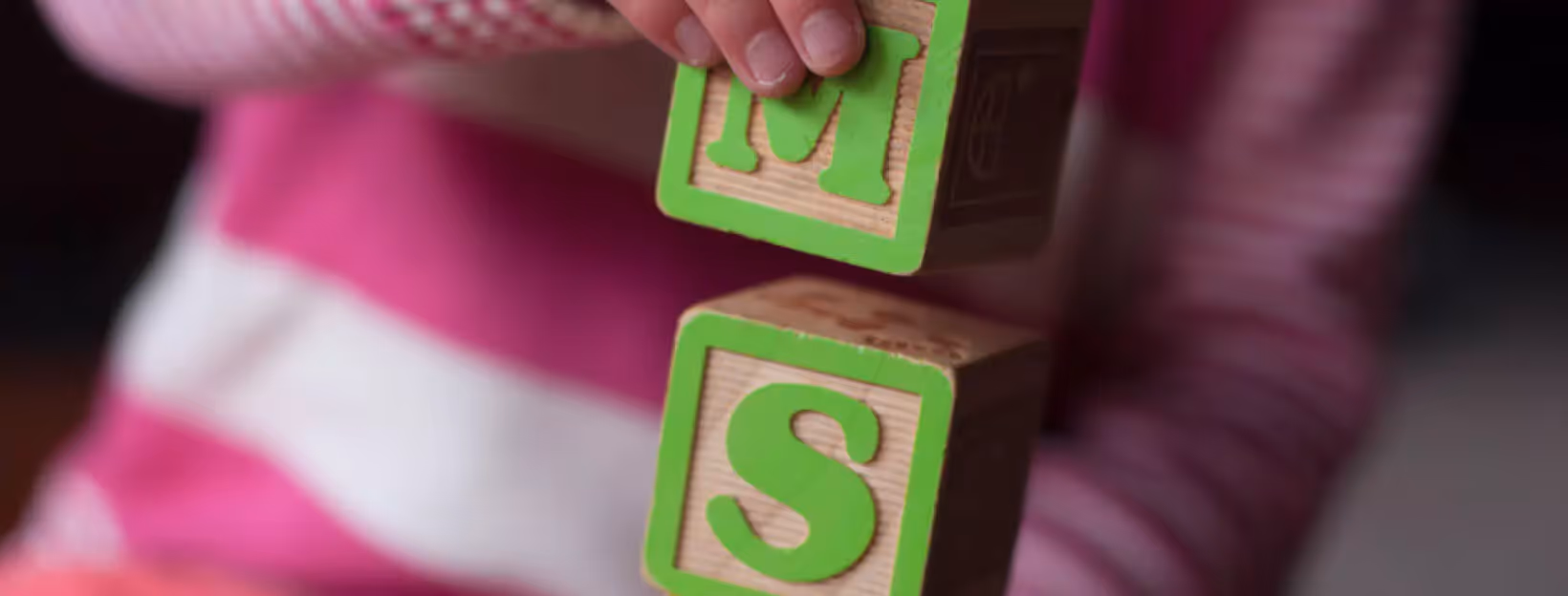 a kid playing with wooden cubes