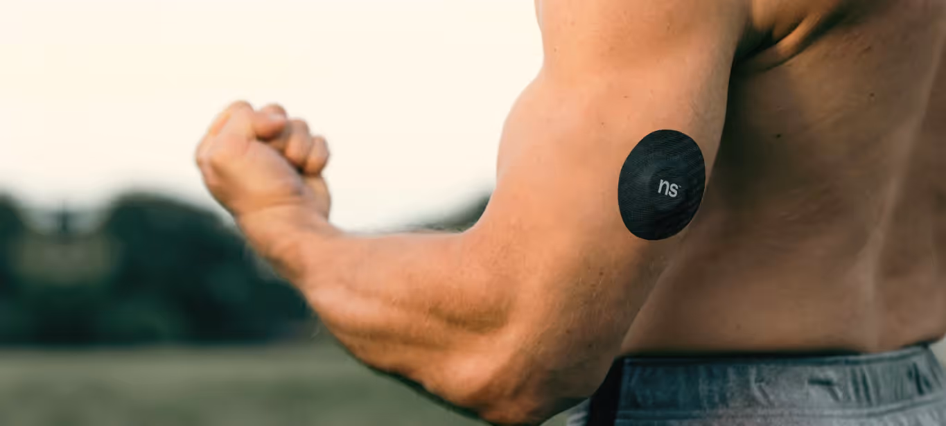 someone flexing their bicep with a cgm on