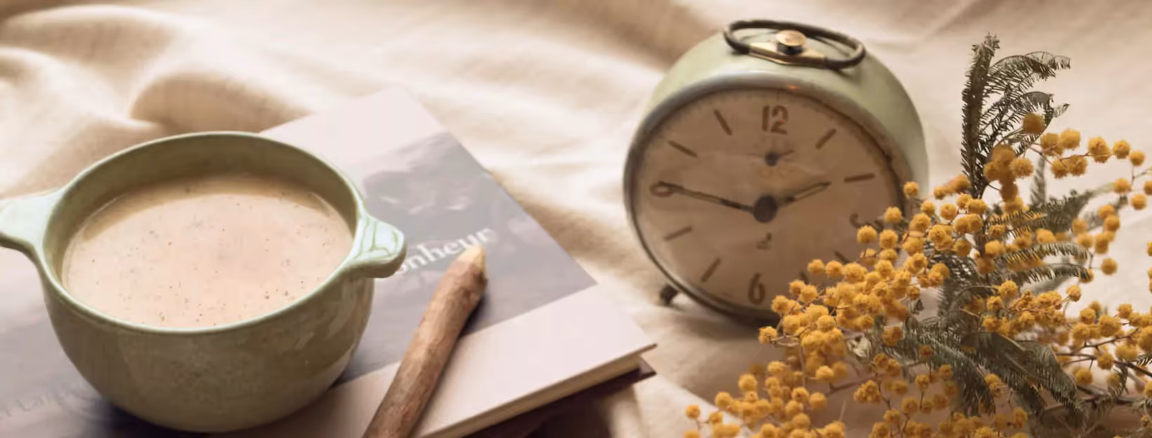 a cup of coffee, a clock and flowers