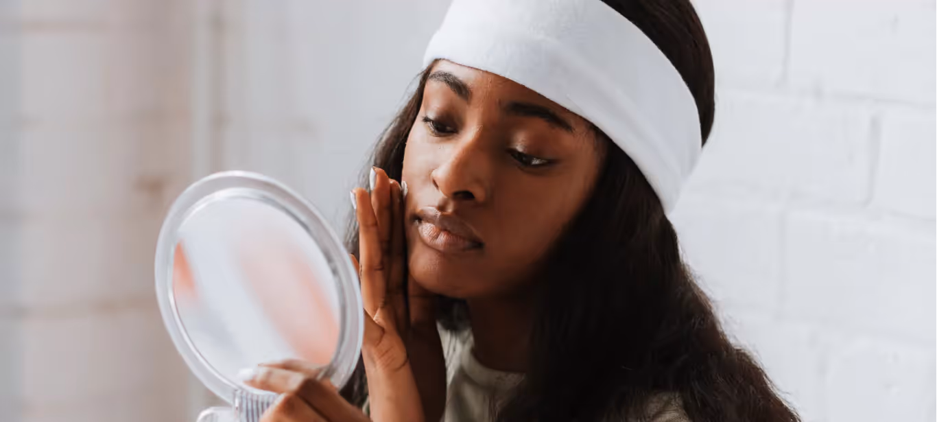 a woman looking at her skin in the mirror