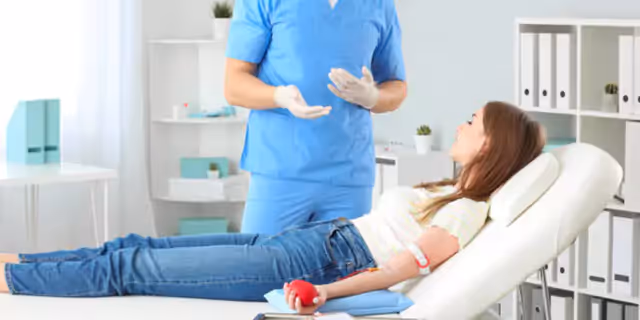 a person donating blood and talking to a doctor