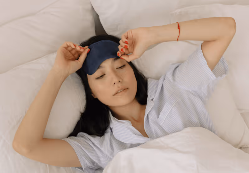 Woman laying in bed with sleeping mask on
