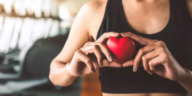 a person holding a heart near the right side of their chest