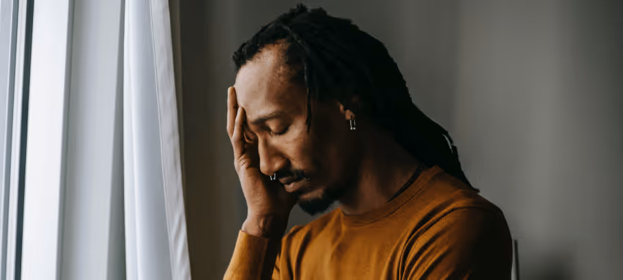 Someone who is sick holding their forehead