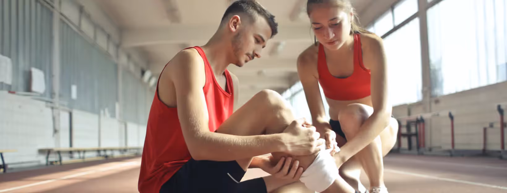 one of two people holding their leg that being injured