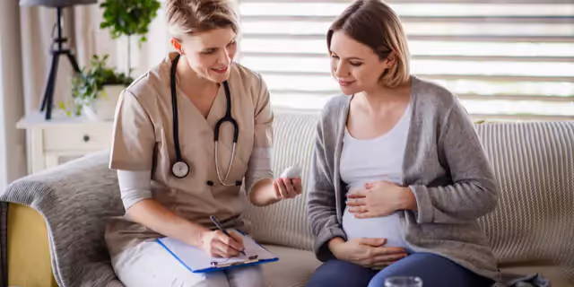a pregnant woman talking to a doctor