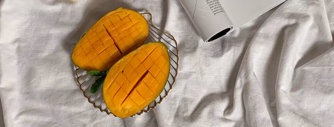 two cut mangoes on a plate