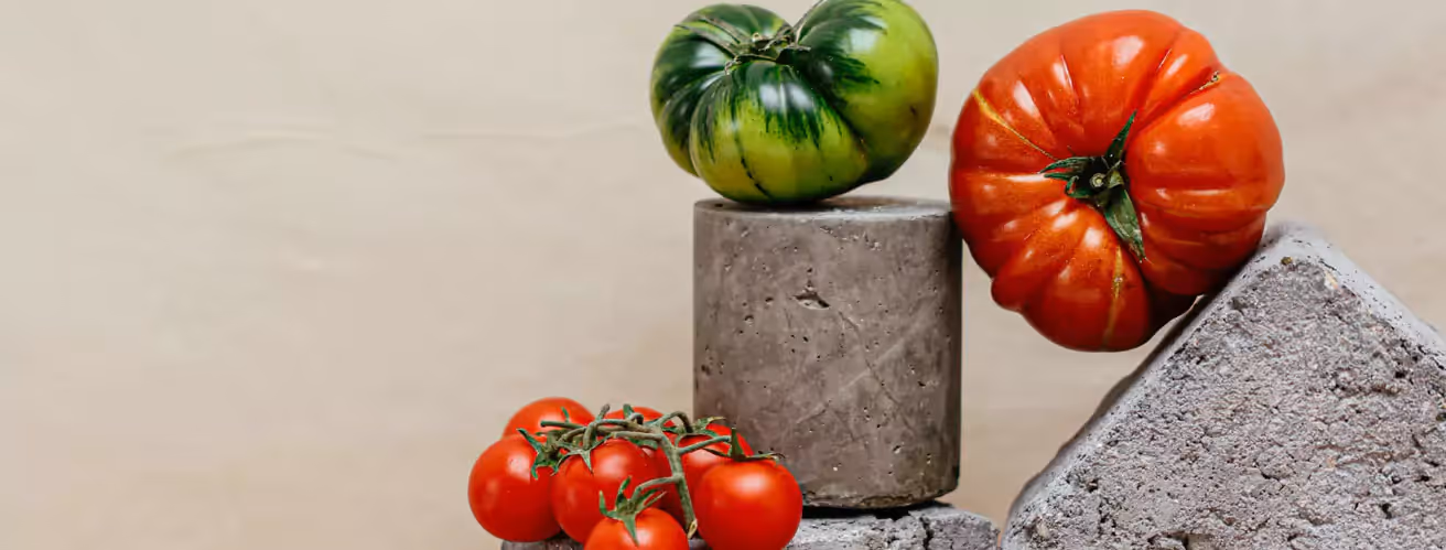 green and red tomatoes on a beige backdrop